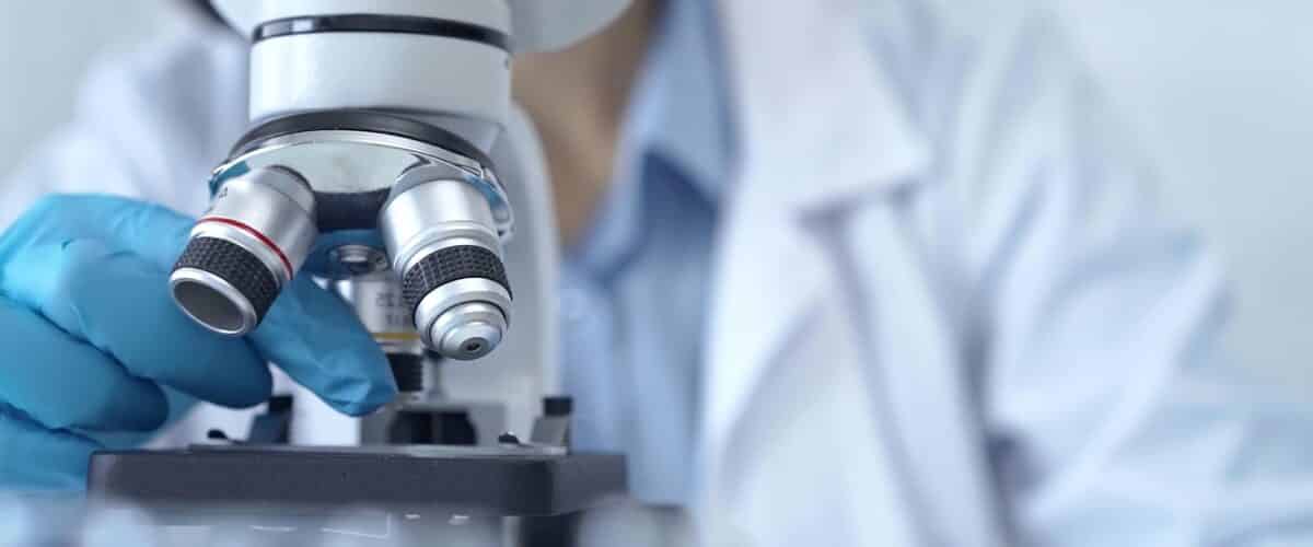 Scientist,using,microscope,in,laboratory.,close Up,of,a,researcher's,hands