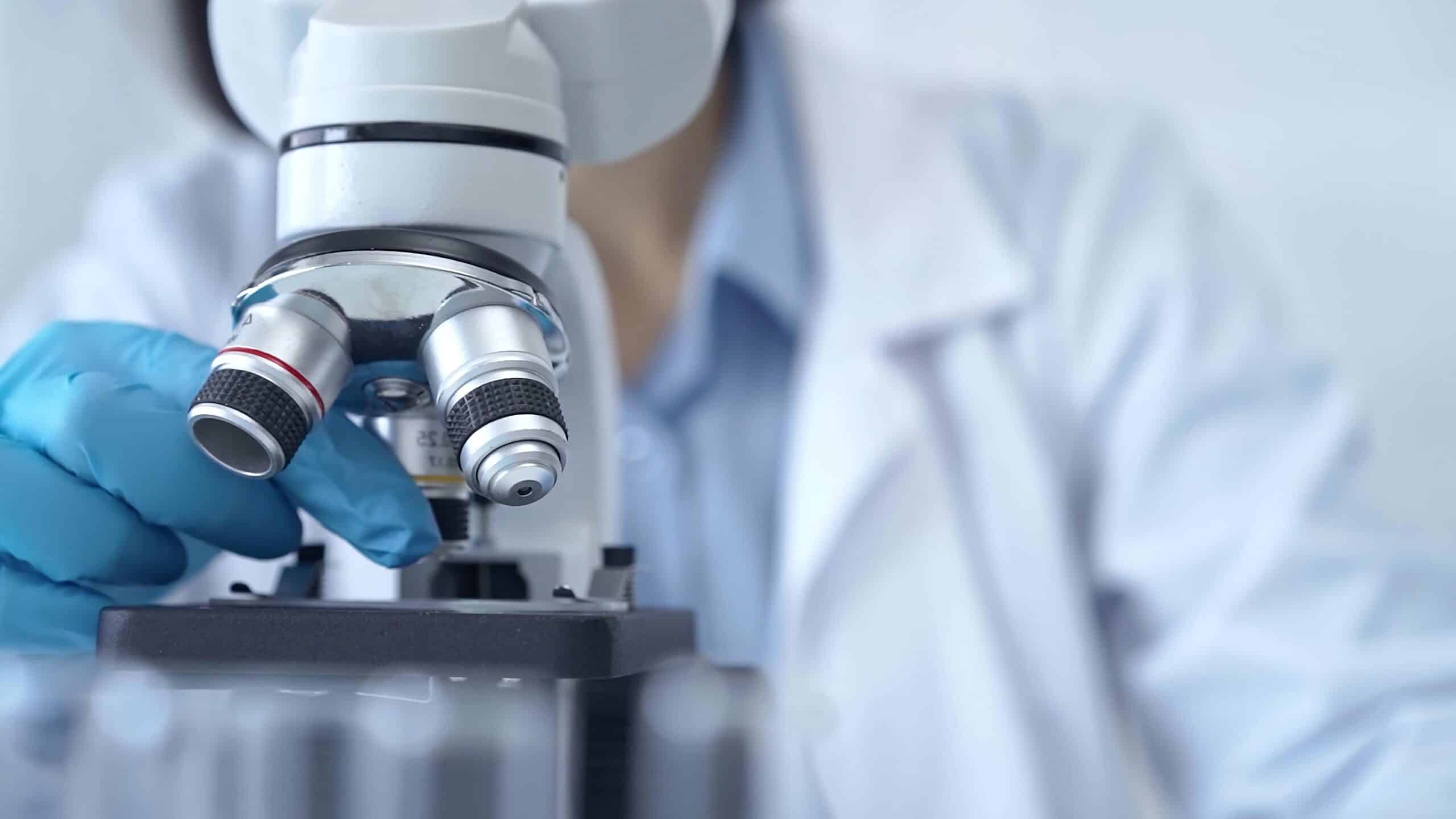 Scientist,using,microscope,in,laboratory.,close Up,of,a,researcher's,hands