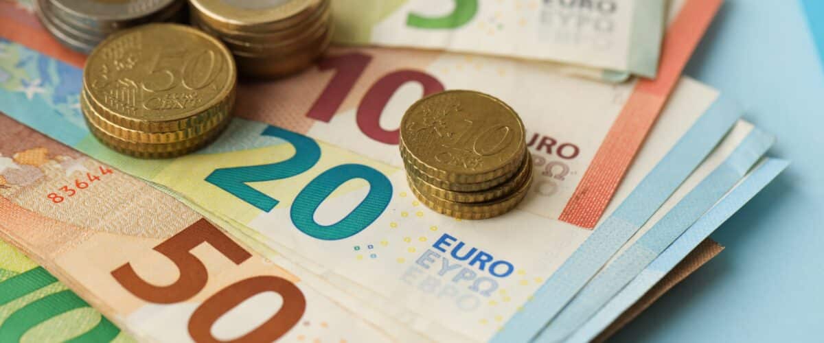 European,union,euro,money,bills,and,coins,on,blue,table